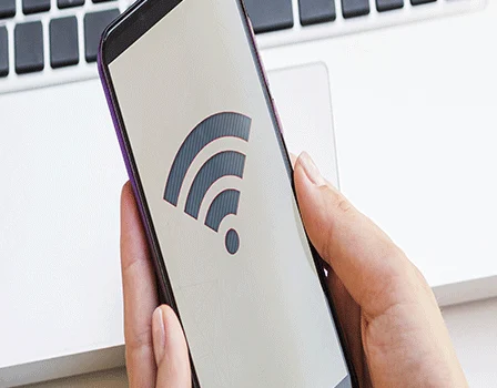 mão segurando celular com símbolo de conexão e senha de wi-fi