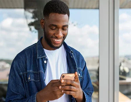 Homem mexendo no celular e sorrindo